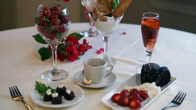 Assorted desserts on a plate with coffee and an after dinner cocktail